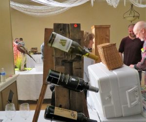 Rustic wine rack auction item holding three bottles at the Night of the Hunter dinner